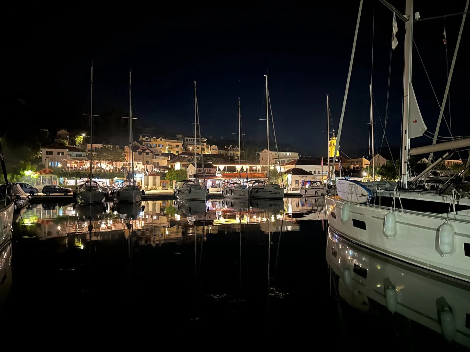 A quiet harbour at night with village lights reflected